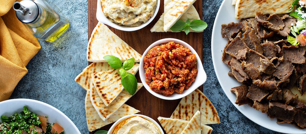 Fresh pita bread, Mediterranean dips, and sliced shawarma meat featured on the La Marsa blog