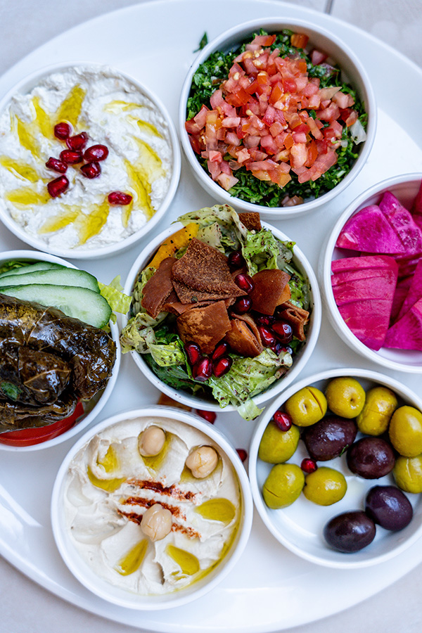 Fresh fattoush salad, hummus, and stuffed grape leaves featured on the La Marsa Mediterranean restaurant menu